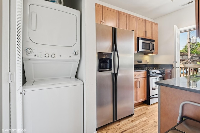 3414 N Racine Ave Unit 2, Chicago, IL 60657 - kitchen featuring appliances with stainless steel finishes, stacked washer and clothes dryer, and light wood-style flooring