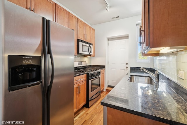 3414 N Racine Ave Unit 2, Chicago, IL 60657 - kitchen with stainless steel appliances, decorative backsplash, dark stone counters, light wood finished floors, and rail lighting