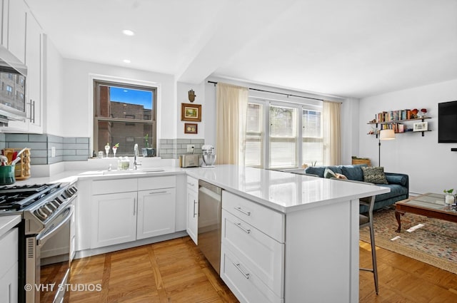 1585 Ridge Ave Unit 110, Evanston, IL 60201 - kitchen featuring appliances with stainless steel finishes, plenty of natural light, a peninsula, a kitchen breakfast bar, and recessed lighting