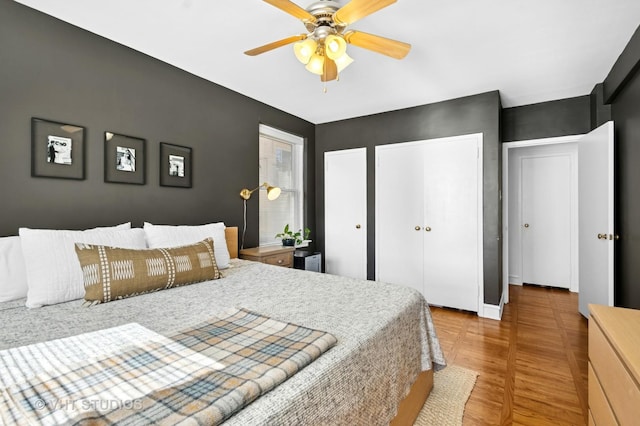 1585 Ridge Ave Unit 110, Evanston, IL 60201 - bedroom with multiple closets, wood finished floors, and ceiling fan