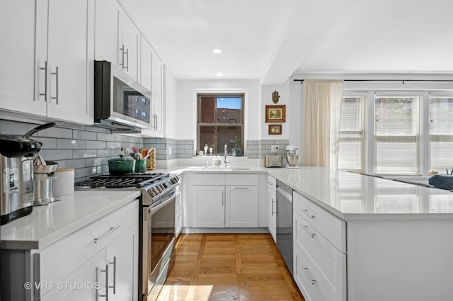 1585 Ridge Ave Unit 110, Evanston, IL 60201 - kitchen with appliances with stainless steel finishes, a peninsula, healthy amount of natural light, backsplash, and recessed lighting