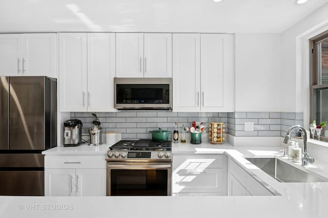 1585 Ridge Ave Unit 110, Evanston, IL 60201 - kitchen featuring stainless steel appliances, white cabinetry, light countertops, backsplash, and recessed lighting