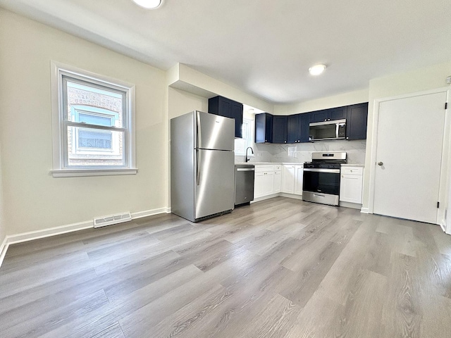 4937 S Kilpatrick Ave, Chicago, IL 60632 - kitchen featuring appliances with stainless steel finishes, light countertops, light wood finished floors, a sink, and baseboards