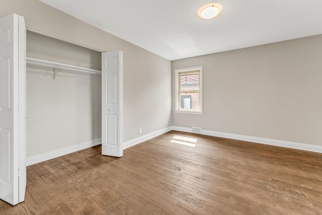 10026 Spaulding Ave, Evergreen Park, IL 60805 - unfurnished bedroom with wood finished floors, baseboards, and a closet