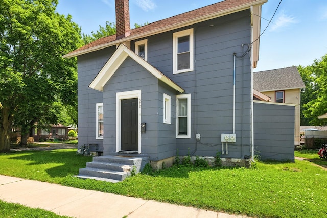 650 Pennsylvania Ave, Aurora, IL 60506 - view of front facade with a chimney and a front yard