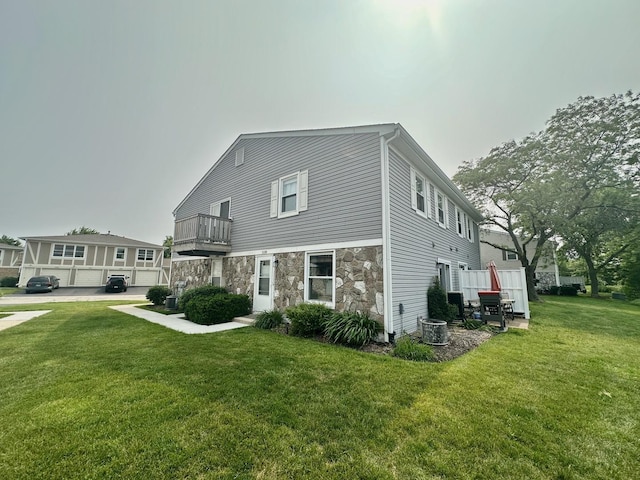 1110 Hampton Hbr Unit 1110, Schaumburg, IL 60193 - rear view of house featuring stone siding, a balcony, a yard, and central AC