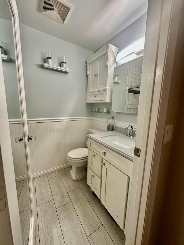 1110 Hampton Hbr Unit 1110, Schaumburg, IL 60193 - bathroom featuring wainscoting, vanity, toilet, and wood tiled floors
