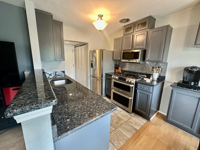 1110 Hampton Hbr Unit 1110, Schaumburg, IL 60193 - kitchen with appliances with stainless steel finishes, a peninsula, a sink, backsplash, and dark stone countertops