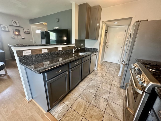 1110 Hampton Hbr Unit 1110, Schaumburg, IL 60193 - kitchen featuring stainless steel appliances, dark stone countertops, a sink, a peninsula, and tasteful backsplash