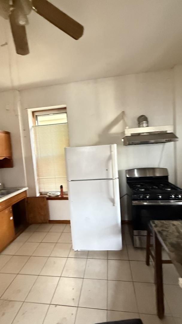 2816 S Lowe St, Chicago, IL 60616 - kitchen with freestanding refrigerator, stainless steel range with gas stovetop, wall chimney exhaust hood, and light tile patterned flooring