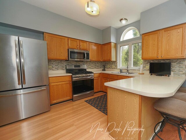 34251 N Homestead Rd, Gurnee, IL 60031 - kitchen with stainless steel appliances, tasteful backsplash, light countertops, a peninsula, and light wood-style flooring