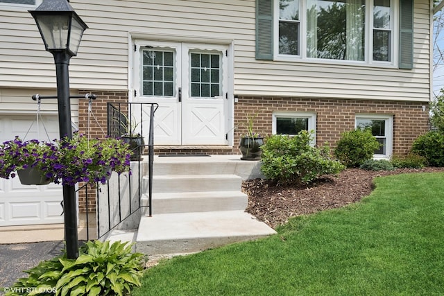 505 Crest Dr, Cary, IL 60013 - view of exterior entry with brick siding and a lawn