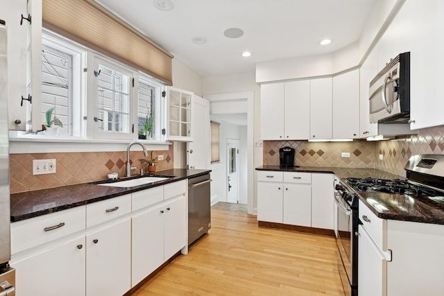720 Ingleside Pl, Evanston, IL 60201 - kitchen featuring stainless steel appliances, light wood-type flooring, white cabinetry, tasteful backsplash, and dark stone countertops