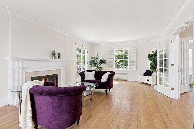 720 Ingleside Pl, Evanston, IL 60201 - sitting room featuring radiator, light wood-type flooring, crown molding, a tile fireplace, and french doors