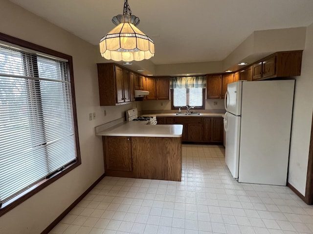 310 Massasoit St, Minooka, IL 60447 - kitchen with white appliances, a sink, a peninsula, under cabinet range hood, and light countertops