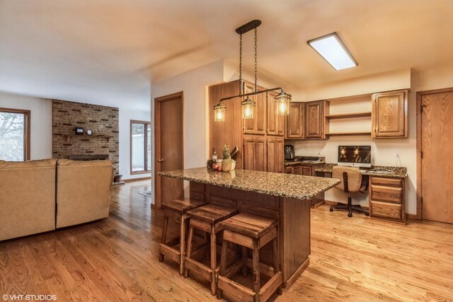 1908 Hazelwood Dr, Lindenhurst, IL 60046 - kitchen with light wood-style floors, open shelves, a peninsula, brown cabinets, and dark stone counters