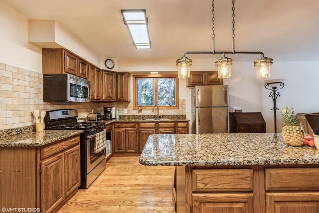 1908 Hazelwood Dr, Lindenhurst, IL 60046 - kitchen featuring appliances with stainless steel finishes, light wood-style flooring, decorative backsplash, and stone counters