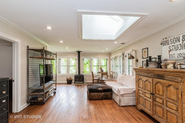 26821 N Oakdale Ln, Mundelein, IL 60060 - living area featuring a wood stove, wood finished floors, crown molding, recessed lighting, and a skylight