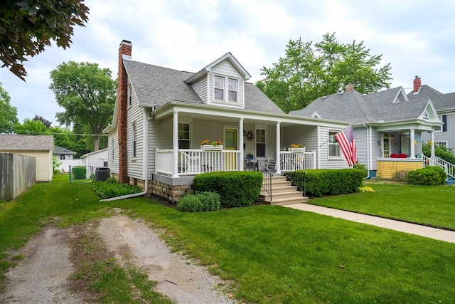 735 W Henry St, Pontiac, IL 61764 - view of front of property with covered porch, a shingled roof, a front lawn, and a chimney