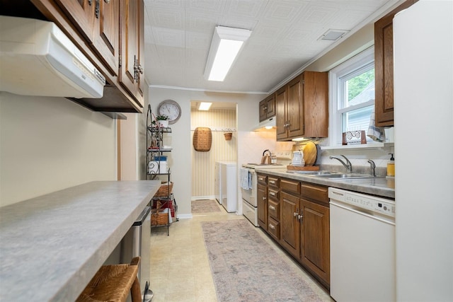 735 W Henry St, Pontiac, IL 61764 - kitchen featuring white appliances, washer and clothes dryer, extractor fan, under cabinet range hood, and brown cabinetry