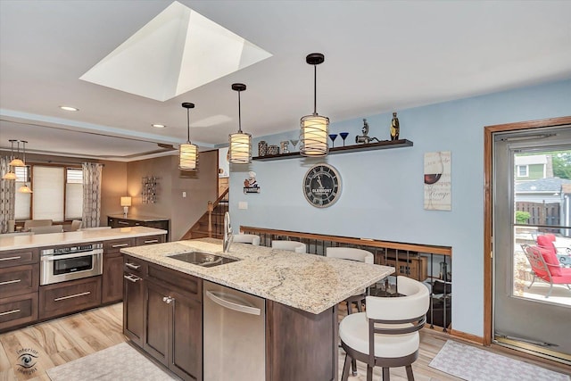 3242 W 108th Pl, Chicago, IL 60655 - kitchen featuring appliances with stainless steel finishes, light wood-style floors, a breakfast bar area, dark brown cabinetry, and recessed lighting