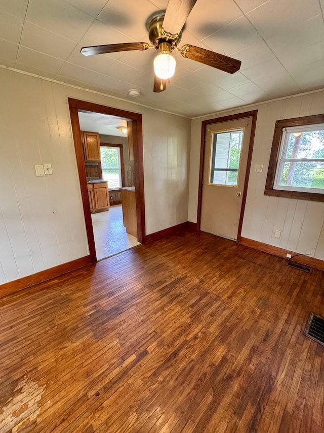1202 E Water St, Pontiac, IL 61764 - spare room featuring wood-type flooring, plenty of natural light, baseboards, and wood walls