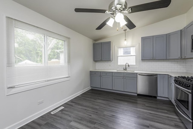 907 Lorelei Dr, Zion, IL 60099 - kitchen featuring appliances with stainless steel finishes, gray cabinets, vaulted ceiling, decorative backsplash, and light countertops