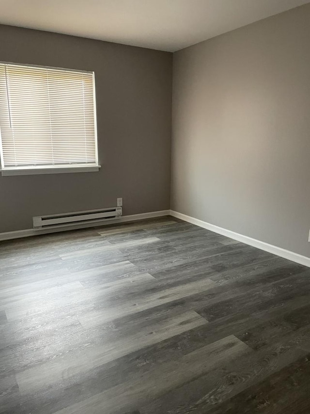 1389 Monomoy St Unit B2, Aurora, IL 60506 - empty room with a baseboard heating unit and dark wood-type flooring
