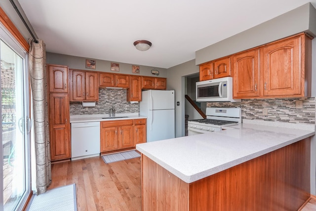 350 Kathy Dr, Bourbonnais, IL 60914 - kitchen with white appliances, decorative backsplash, light countertops, and brown cabinetry
