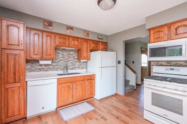 350 Kathy Dr, Bourbonnais, IL 60914 - kitchen featuring white appliances, tasteful backsplash, light countertops, light wood-style flooring, and brown cabinetry
