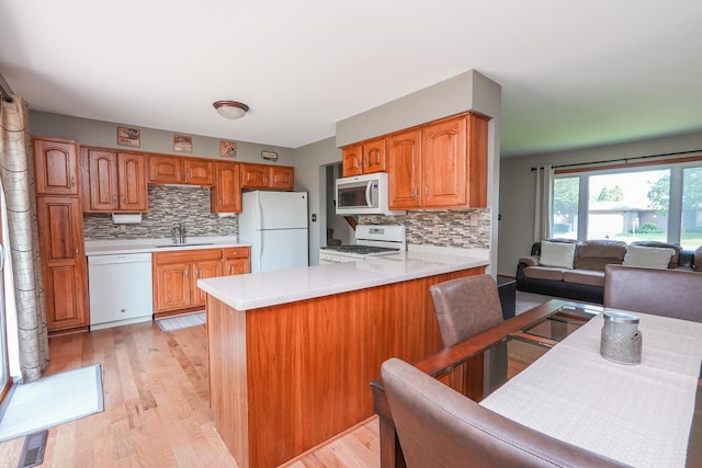 350 Kathy Dr, Bourbonnais, IL 60914 - kitchen with white appliances, light countertops, a peninsula, and decorative backsplash