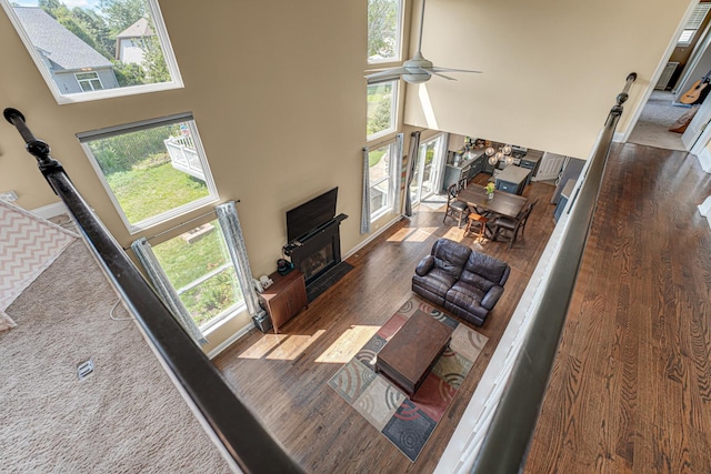 2316 Loop Rd, Algonquin, IL 60102 - living room with a towering ceiling, a fireplace with flush hearth, plenty of natural light, a ceiling fan, and wood finished floors