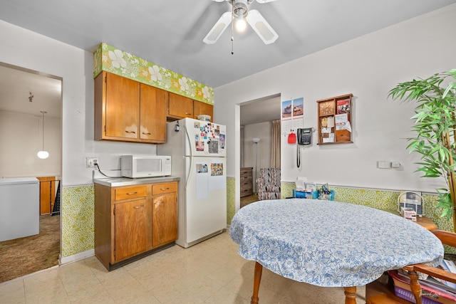 7325 173rd St, Tinley Park, IL 60477 - kitchen featuring white appliances, a ceiling fan, light countertops, brown cabinetry, and a wainscoted wall
