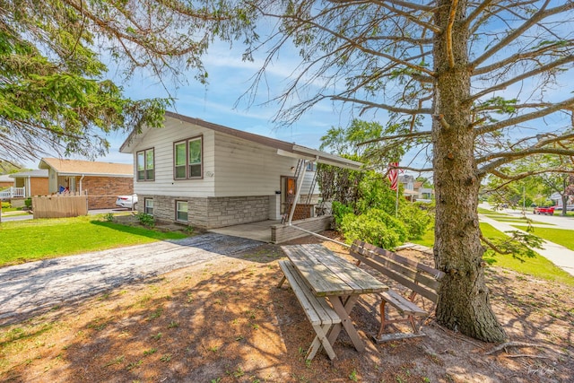 7325 173rd St, Tinley Park, IL 60477 - view of front of property featuring dirt driveway, a front lawn, an attached carport, and stone siding