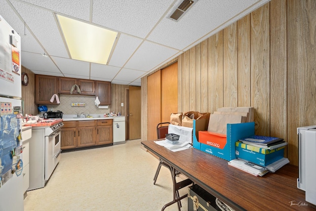 7325 173rd St, Tinley Park, IL 60477 - kitchen featuring a paneled ceiling, double oven range, wooden walls, brown cabinetry, and light countertops