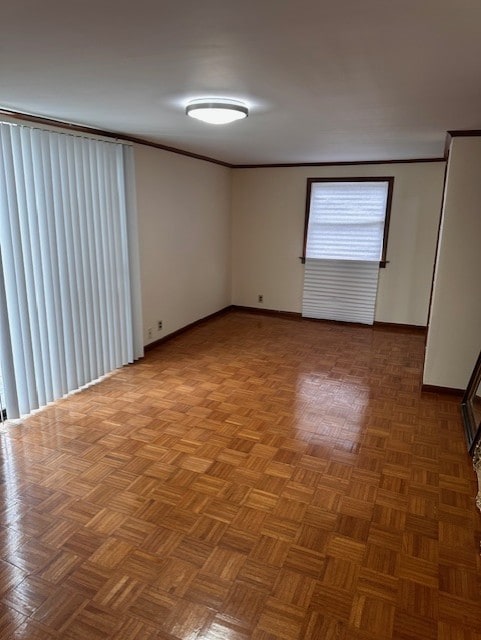 unfurnished room featuring baseboards and crown molding