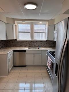 kitchen featuring stainless steel dishwasher, refrigerator with ice dispenser, gas range, and gray cabinetry