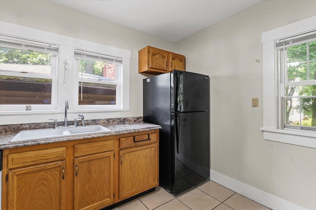 426 S Mcclellan St, Decatur, IL 62522 - kitchen with freestanding refrigerator, light tile patterned flooring, brown cabinets, and dark countertops