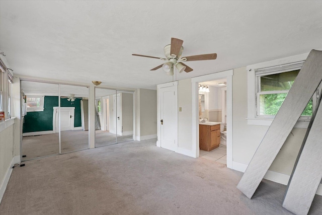 426 S Mcclellan St, Decatur, IL 62522 - unfurnished bedroom featuring multiple closets, light carpet, connected bathroom, and a ceiling fan