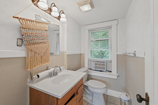 426 S Mcclellan St, Decatur, IL 62522 - half bathroom with vanity, tile walls, tile patterned floors, a wainscoted wall, and a textured ceiling