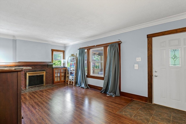 426 S Mcclellan St, Decatur, IL 62522 - unfurnished living room with a brick fireplace, a textured ceiling, crown molding, and dark wood-type flooring