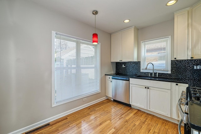 165 S Commonwealth Ave, Elgin, IL 60123 - kitchen featuring stainless steel appliances, decorative backsplash, light wood-style floors, dark countertops, and recessed lighting