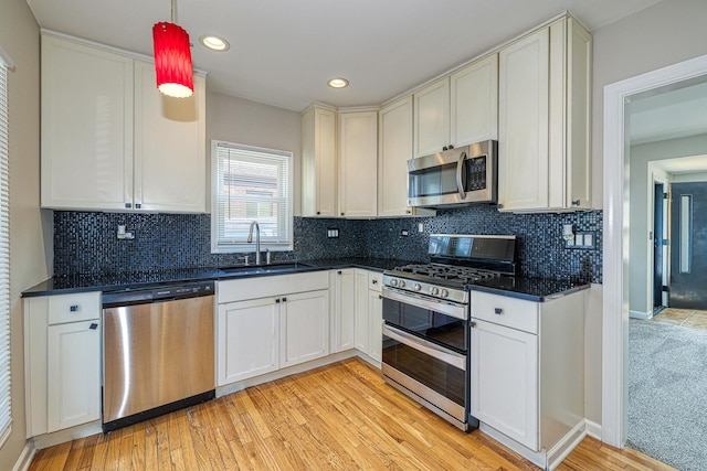 165 S Commonwealth Ave, Elgin, IL 60123 - kitchen with appliances with stainless steel finishes, light wood-style floors, decorative backsplash, recessed lighting, and hanging light fixtures