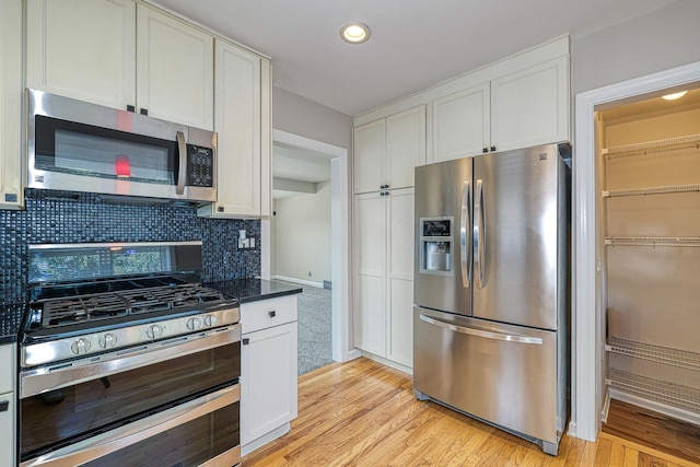 165 S Commonwealth Ave, Elgin, IL 60123 - kitchen featuring appliances with stainless steel finishes, light wood-style floors, tasteful backsplash, white cabinets, and recessed lighting