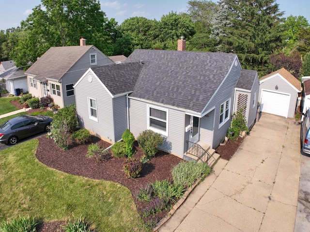 165 S Commonwealth Ave, Elgin, IL 60123 - view of front of property with an outdoor structure, a shingled roof, a garage, a chimney, and concrete driveway