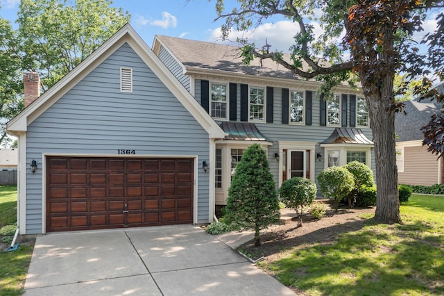 1364 Yorkshire Ln, Carol Stream, IL 60188 - colonial home with concrete driveway, an attached garage, a chimney, a standing seam roof, and a metal roof