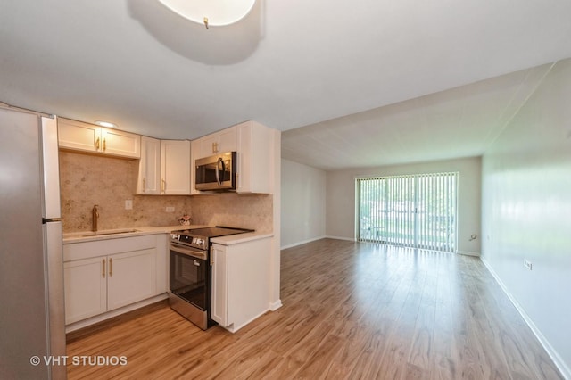 127 N Wolf Rd Unit 52A, Wheeling, IL 60090 - kitchen featuring stainless steel appliances, decorative backsplash, light wood-type flooring, light countertops, and open floor plan