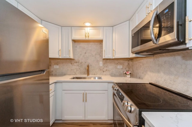 127 N Wolf Rd Unit 52A, Wheeling, IL 60090 - kitchen with stainless steel appliances, light countertops, white cabinetry, backsplash, and wood finished floors