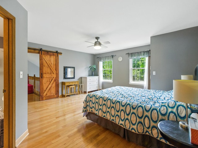 1386 Laurel Oaks Dr, Streamwood, IL 60107 - bedroom featuring a barn door, light wood finished floors, and ceiling fan
