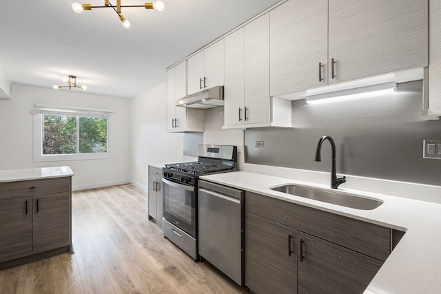 2000 Bayside Dr Unit 204, Palatine, IL 60074 - kitchen featuring stainless steel appliances, under cabinet range hood, a chandelier, light countertops, and light wood-style floors